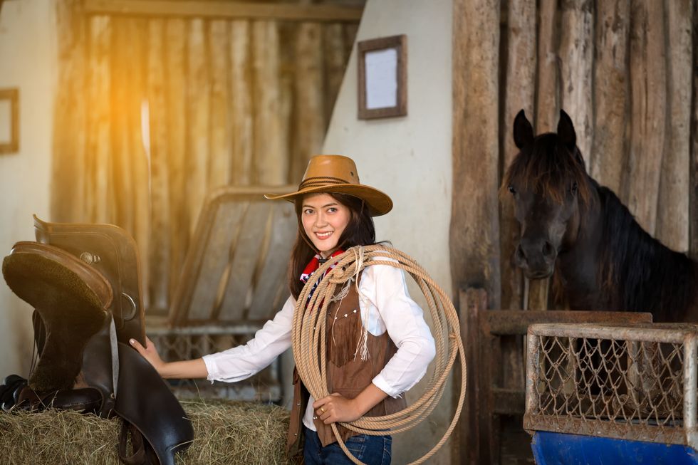 women dressed in cowboy costume with horse in background