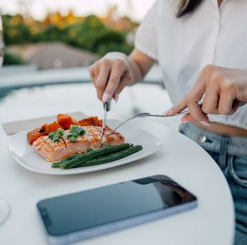 women eating a grilled salmon in a restaurant