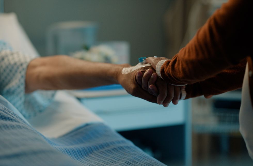 women holding hands on a hospital bed