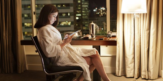 Women in hotel room reading digital tablet