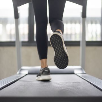 women legs running on treadmill at the fitness gym