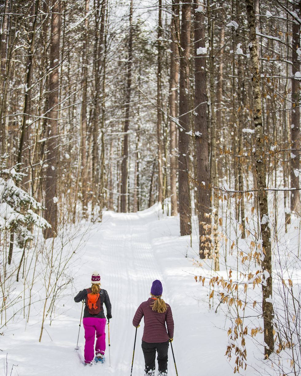 two women snowshoeing in woodstock, vermont usa