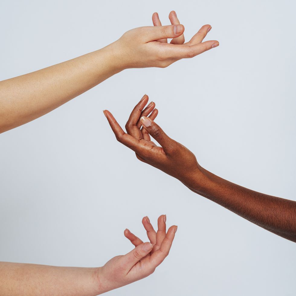 women stretching hands toward each other against white background