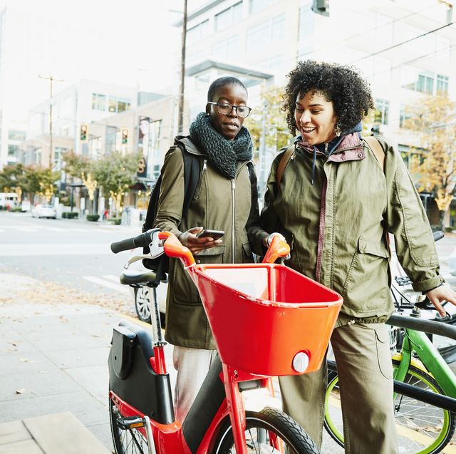 women using smart phone to rent bike share bike