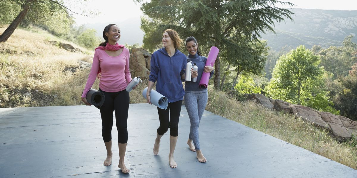 Women with yoga mats talking after class on deck