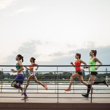 a group of women running group of women jogging along a waterfront pathway