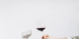 women's hand holding a glass of red wine