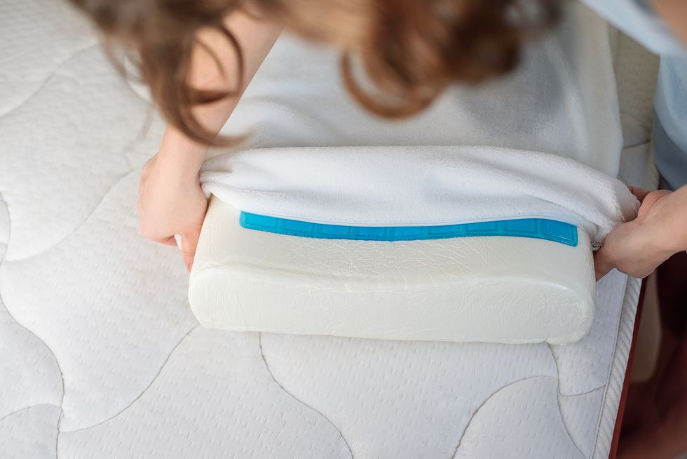 women's hands put a cover on the orthopedic pillow with cooling gel protecting the foam pillow from moisture