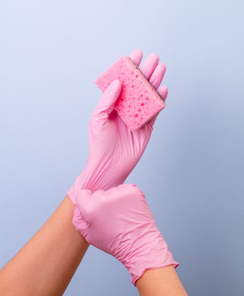 Women's hands wearing pink latex gloves for cleaning