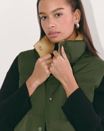 a person adjusting a green and yellow padded vest