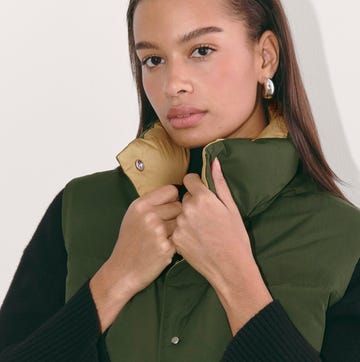 a person adjusting a green and yellow padded vest a person adjusting a green and yellow padded vest