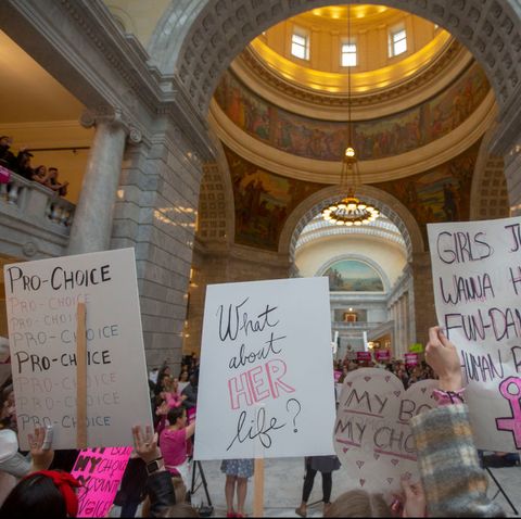 activists hold signs at a rally to oppose abortion bans happening throughout the united states, at the state capitol building