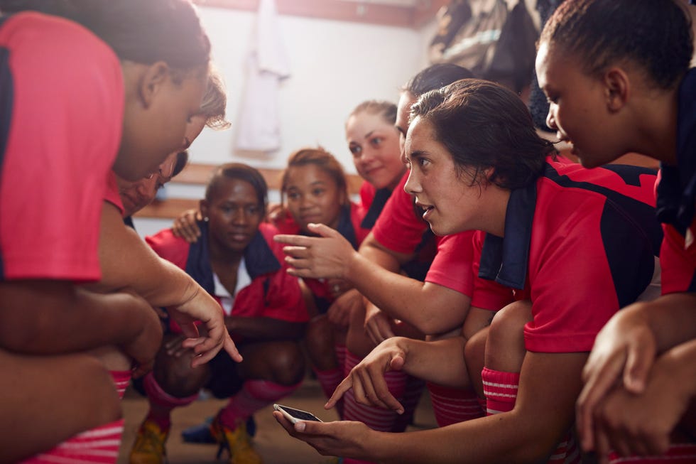 Womens rugby players looking at phone before game