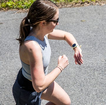A person running on a path while checking a smartwatch a person running on a path while checking a smartwatch