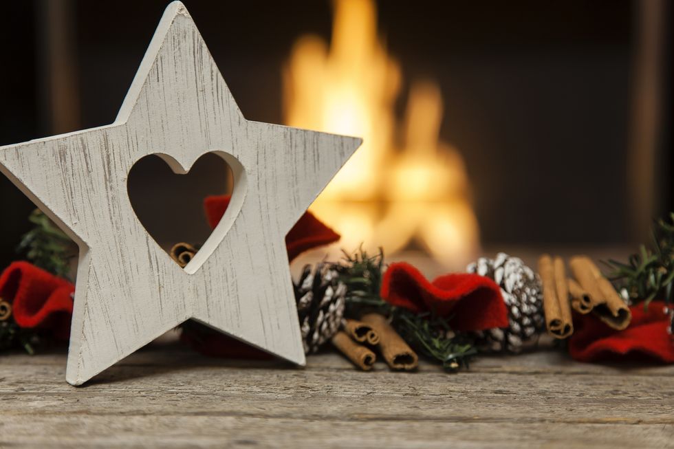 close up shot of christmas decorations neatly arranged on wooden planks by the fireplace horizontal composition with lot of copy space and shallow depth of field
