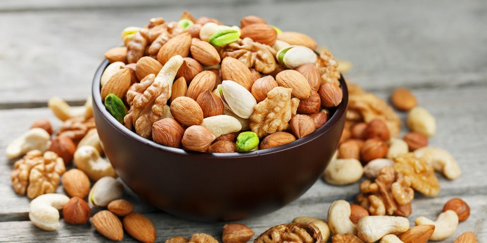 wooden bowl with mixed nuts on a wooden gray background walnut,pistachios,almonds,hazelnuts and,romania