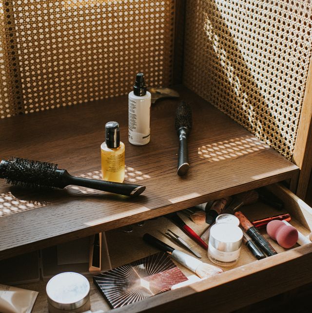 a wooden dressing table in sun with various beauty products