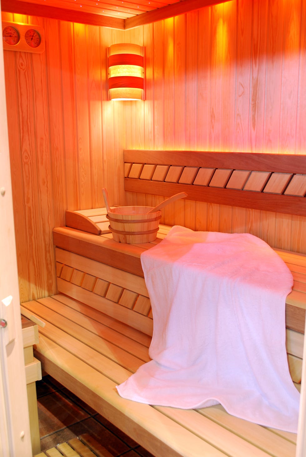 wooden sauna interior with towel and bucket