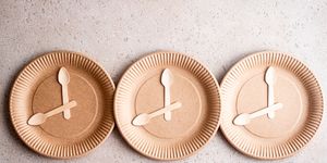 wooden spoons on a biodegradable birch wood disposable plate, top view 168 intermittent fasting concept
