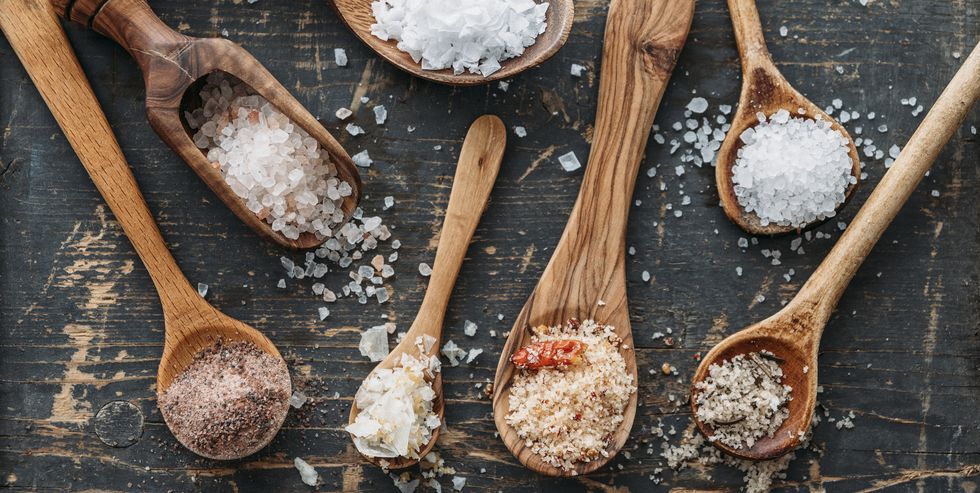 wooden spoons with different sorts of salt