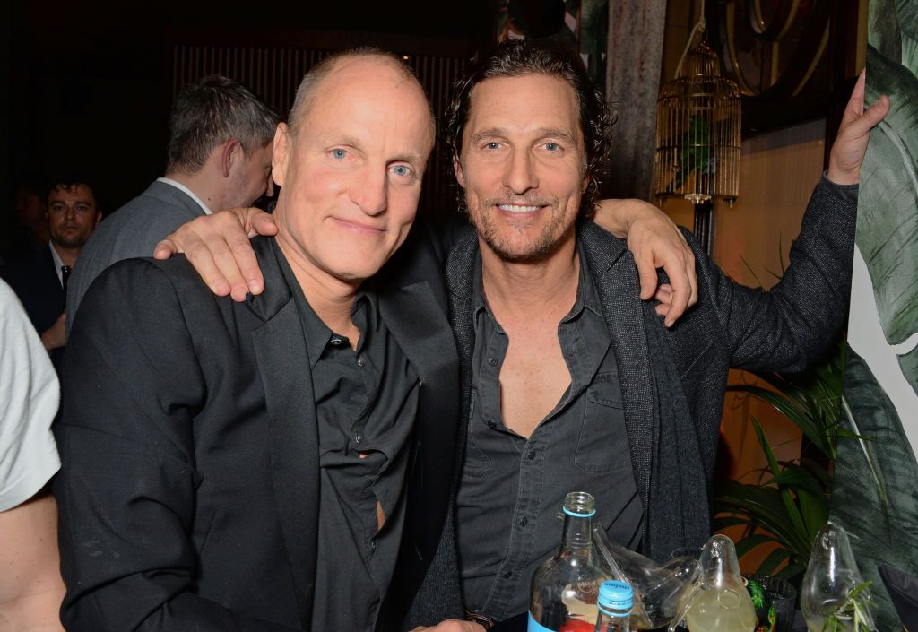 woody harrelson and matthew mcconaughey embracing while sitting at a table