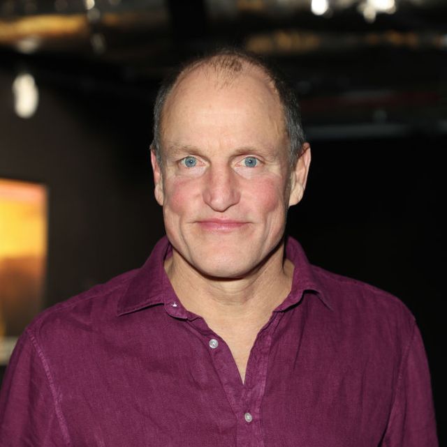 woody harrelson smiles at the camera, he wears a red button up shirt