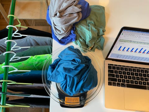 a set of wrinkled clothes is piled on a table, including a blue shirt on a scale