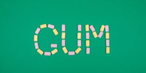 word gum written with chewing gum on green background
