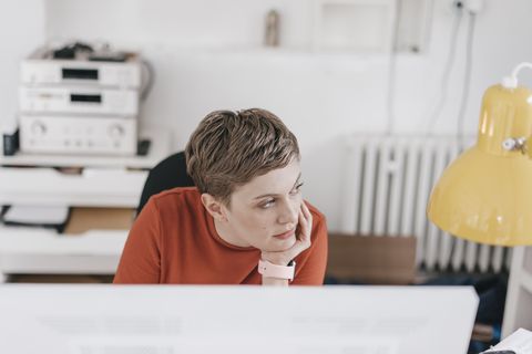 Woman at desk in office thinking