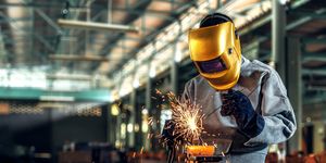 Worker welder working welding steel in industry with safety mask safety gloves and safety equipment. Worker welding concept.