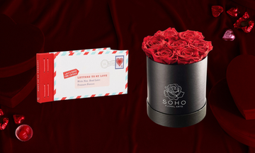 a collection of romantic gifts including a letter keeping book a bouquet of red roses chocolate hearts and heartshaped boxes