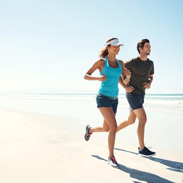 shot of a young couple running antic along the beach together