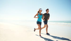 man en vrouw lopen in de zomer over het strand