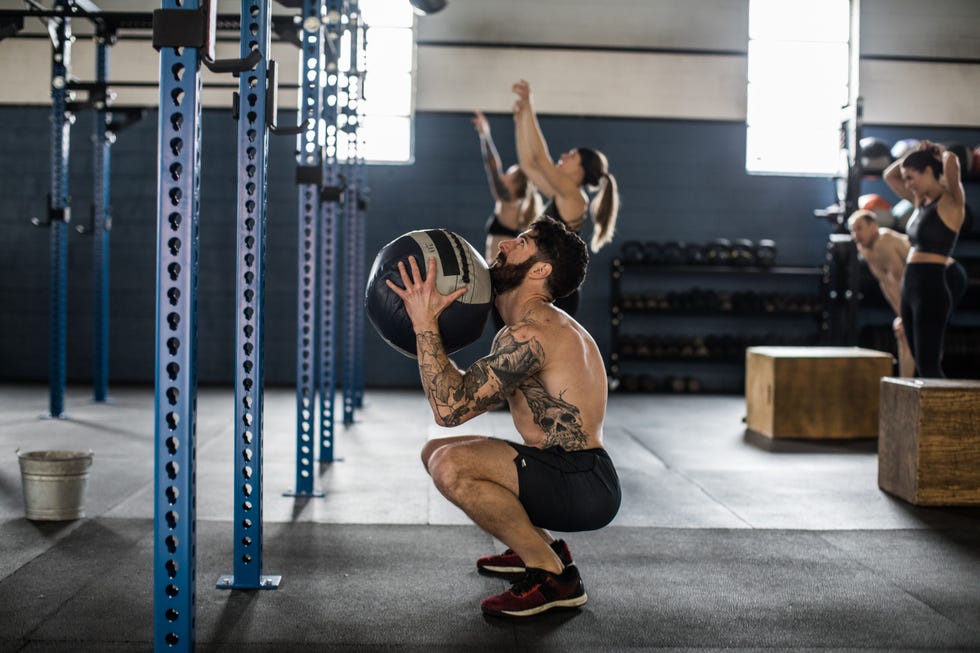 man using medicine ball during exercise class