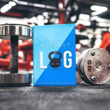 workout log journal with dumbbells in gym
