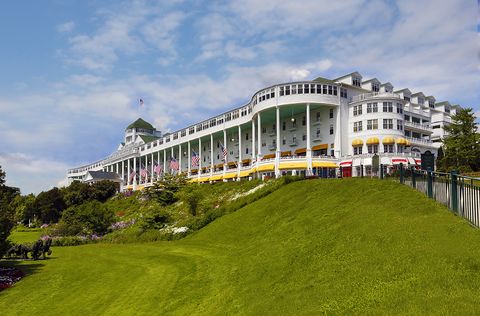 the grand hotel in mackinac island with a lush green lawn and white painted exterior
