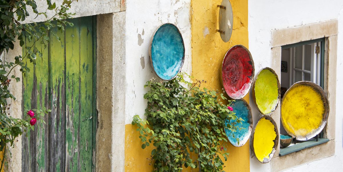 colorful plates hanging on a wall in obidos portugal