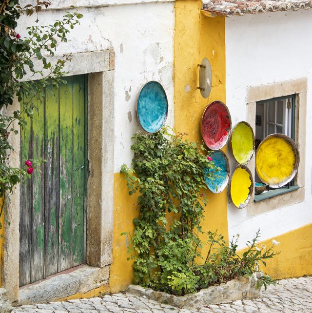 colorful plates hanging on a wall in obidos portugal