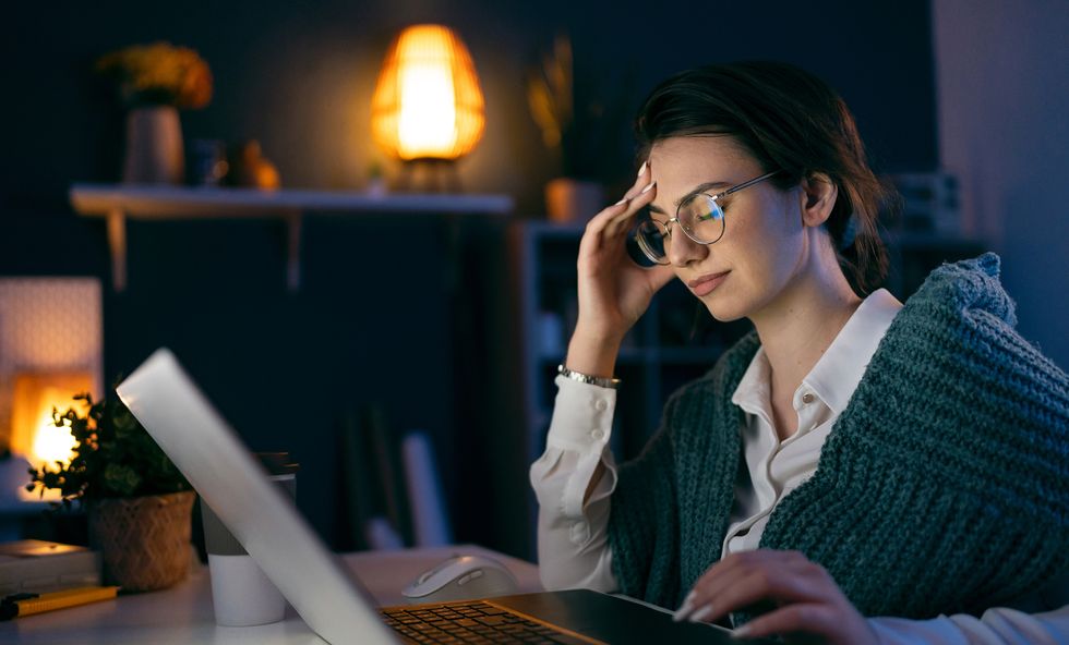 worried businesswoman working late in her home office