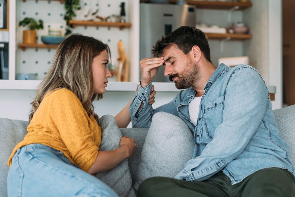 worried couple talking together in the living room at home