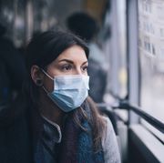worried woman with protective face mask in bus transport