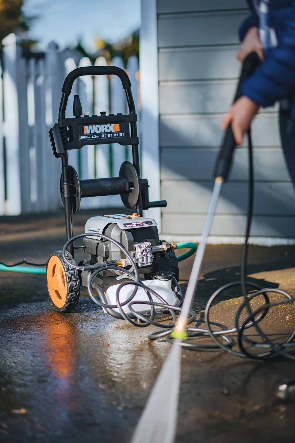 electric pressure washer with a person using it
