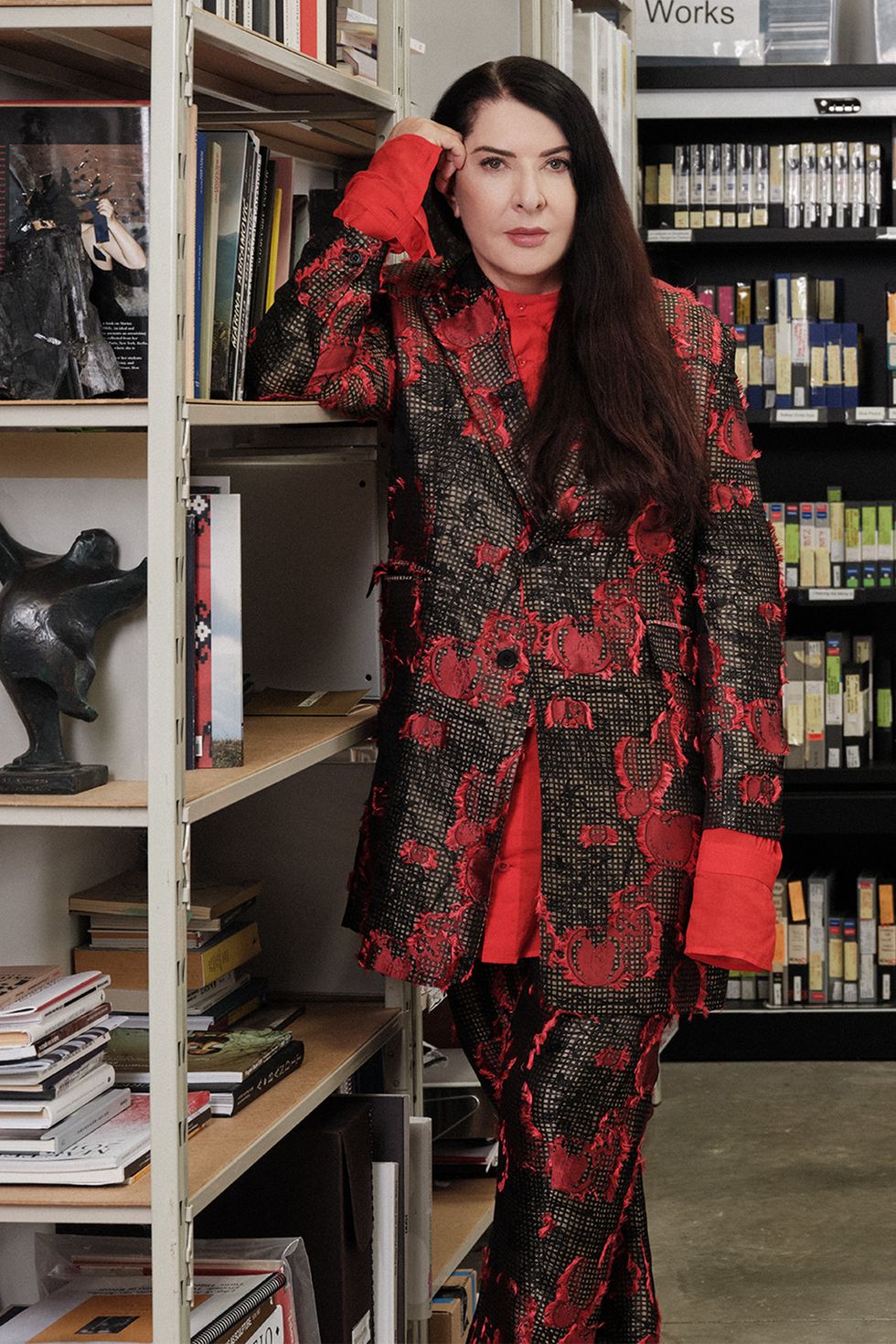 a woman wearing a red and black dress in a room with bookshelves