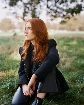 a woman sitting in the grass