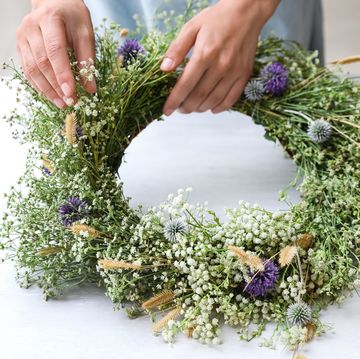 woman making a floral spring wreath