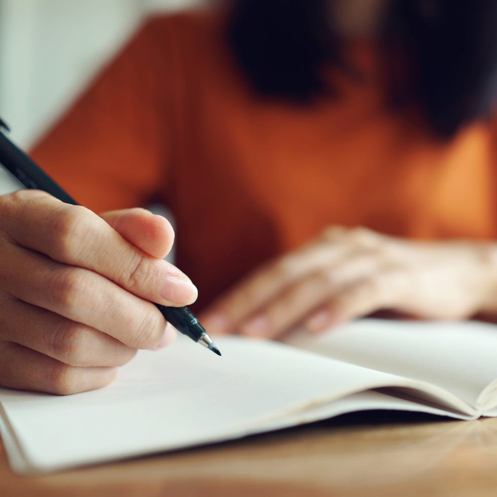 Self-care ideas woman writing in notebook
