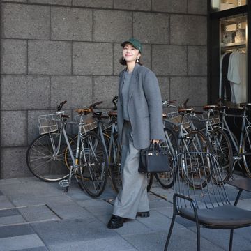 a person standing next to a wall with bicycles