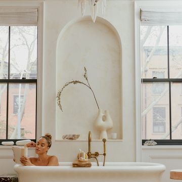 female model reading in tub