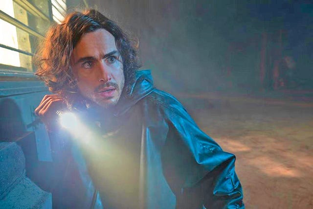 ben schnetzer, agazapado, alumbra con una linterna en una escena de la serie 'y el último hombre' en la que interpreta a yorick