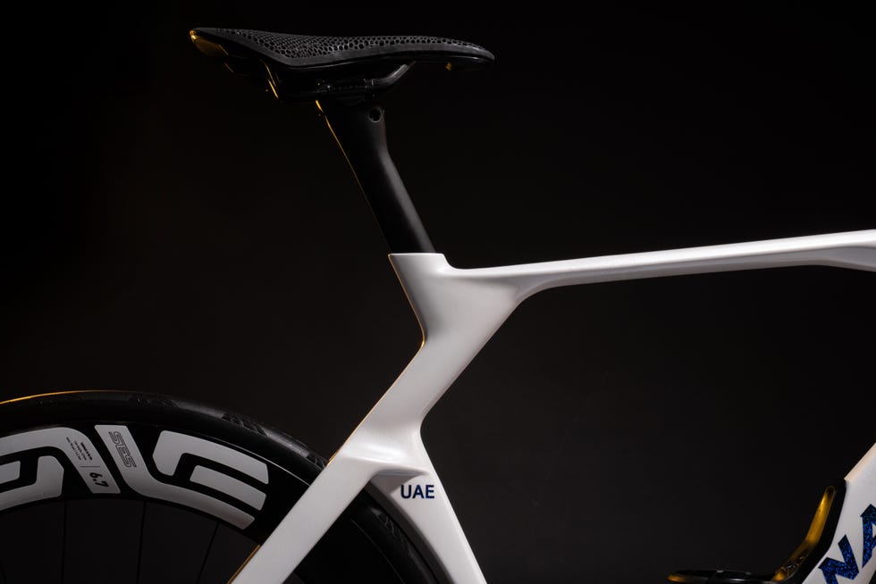 closeup of a white bicycle frame and seat against a dark background